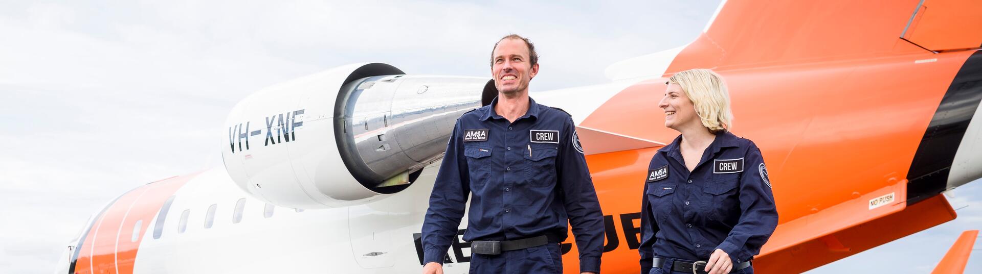 Man and woman walking in front of plane