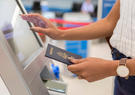 Woman standing at kiosk holding passport