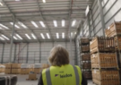 woman in vest standing in warehouse of boxes