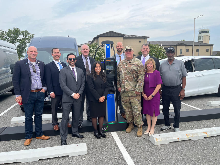 group of people in front of electric vehicle charging station