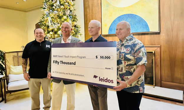 Four men holding an oversized check for $50,000