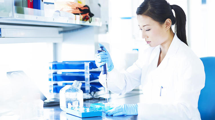 Female scientist filling vials