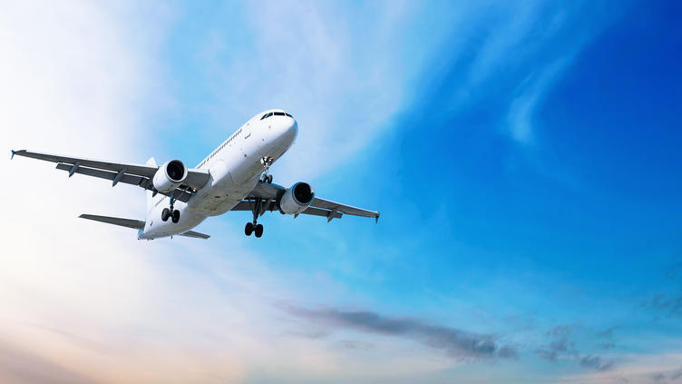 Aircraft in flight in front of blue skies