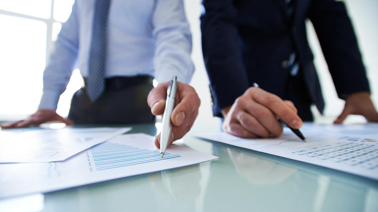 two coworkers reviewing data on paper