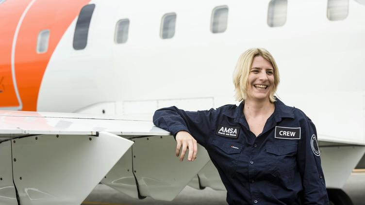 Woman leaning against the wing of a plane