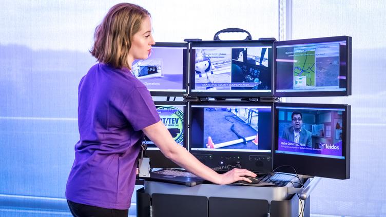 Woman working on multiple screens