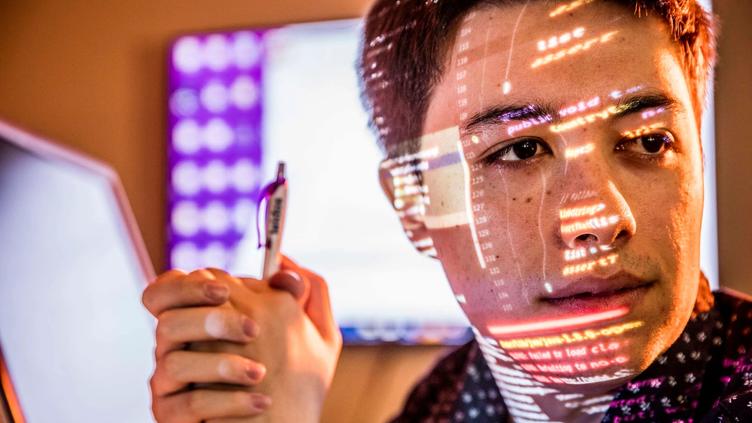 Computer screen reflecting on a mans face